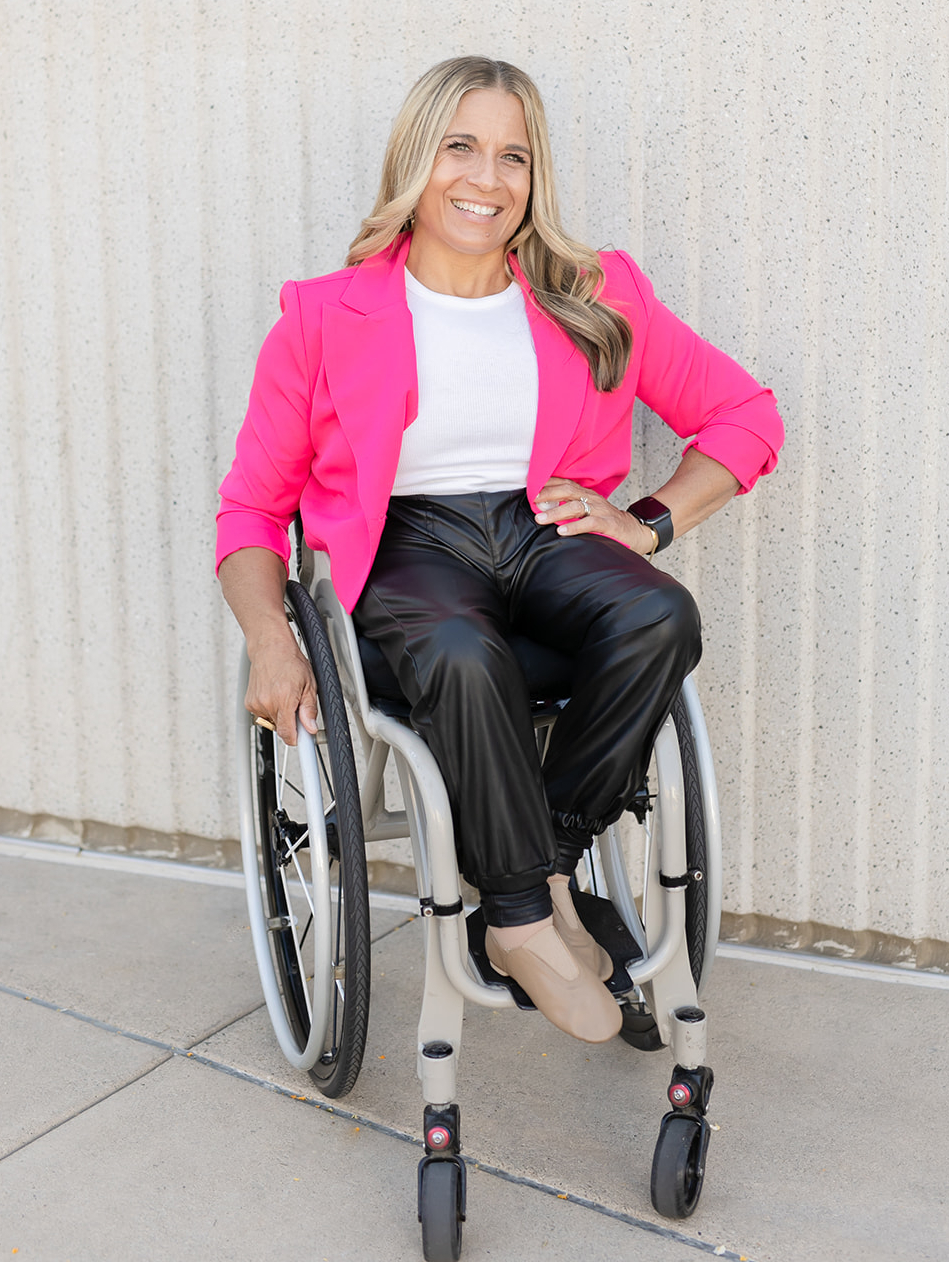 alycia anderson sitting in her wheelchair wearing a pink blazer 